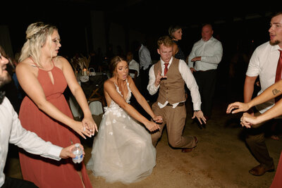 A bride and groom are dancing at their reception.