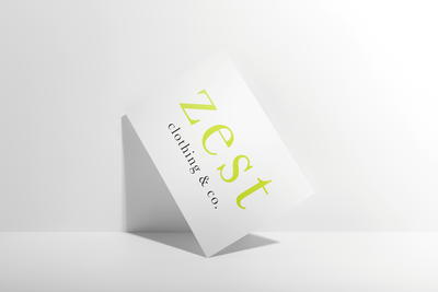 A white card with the text “Zest clothing &amp; co.” in green and black, standing tilted against a white background—showcasing Sweet Pea Ink Creative’s flair for brand design.