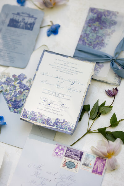 A blue and lilac wedding invitation suite styled with flowers in Atlanta, GA