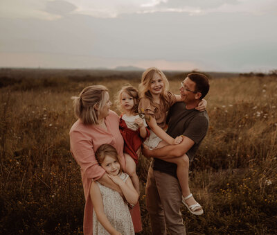 Familiefoto tijdens een familieshoot. Mama, papa en drie dochters.