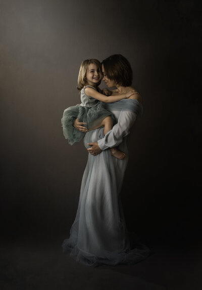 Beautiful mom and daughter snuggling in a portrait studio for an Asheville Photographer