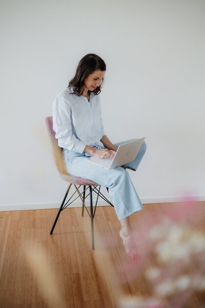 Frau auf Stuhl mit Laptop, Business Fotoshooting