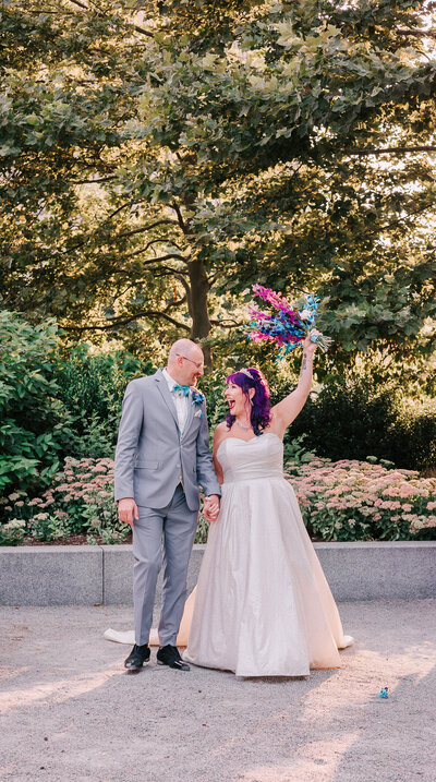 alternative bride and groom walking with colorful bouquet, captured by Ari Leo, a Boston alternative wedding photographer