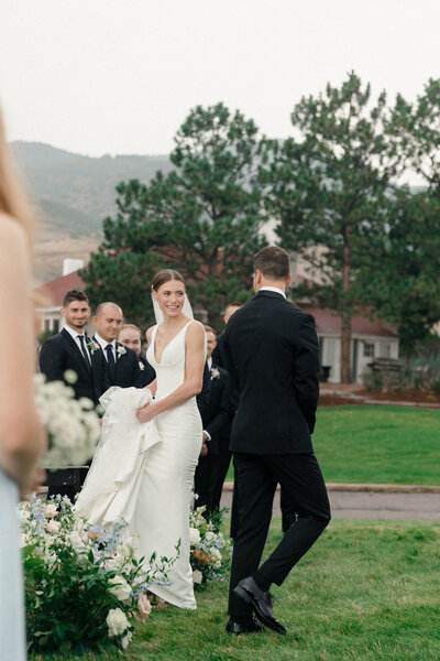 bridal party runs around bride and groom