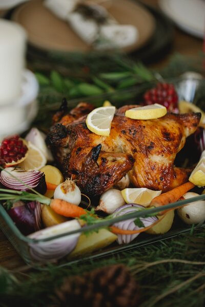 Roasted chicken and colorful vegetables sit in a glass dish. Learn more about healthy private chef culinary services for holistic retreats and day events.