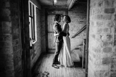 Bride and groom embrace in hallway at Lacuna Loft