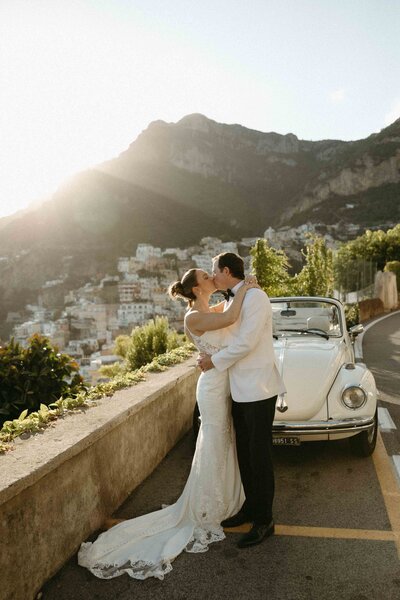 Bride and groom sharing a kiss on a street overlooking the Amalfi Coast