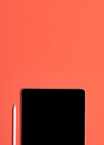Tablet sobre fondo coral oscuro
