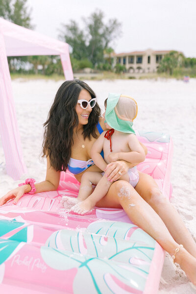 Cassie Loree holding her child sitting on the beach