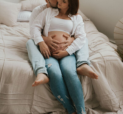 Expecting couple sharing a tender moment during their indoor maternity photoshoot in New York City