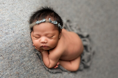 Beautiful baby boy wrapped in a hand knitted  green wrap with matching bonnet.
