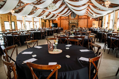 Elegant wedding reception setup with draped ceiling and black table linens