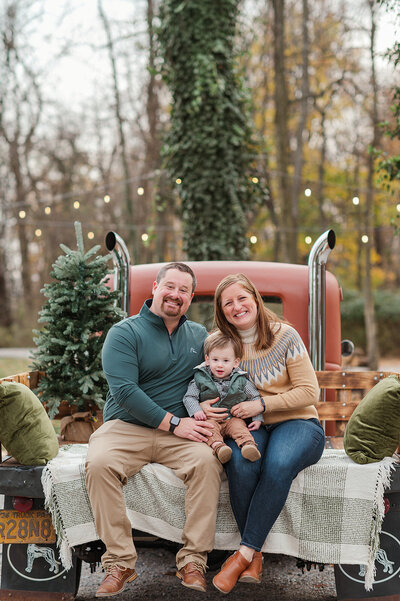 Smiling family sitting on truck bed during Christmas mini session near York, PA