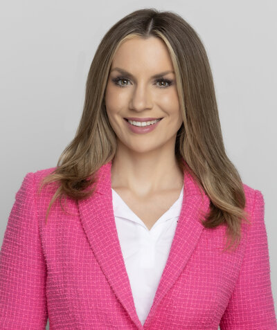 smiling woman wearing a hot pink blazer