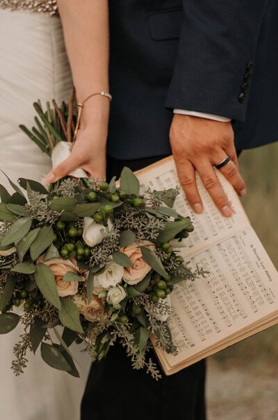 Boho couple in wedding dress with luxury flower bouquet.