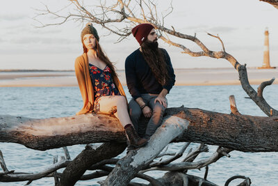 couple sits on driftwood
