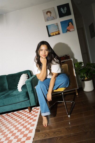 woman sitting on couch playing with her hair