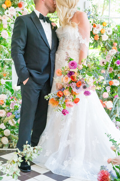 vibrant colorful florals surrounding bride and groom