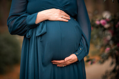 This is a close up of a pregnant woman cradling her belly at her maternity photoshoot in Newnan, GA.