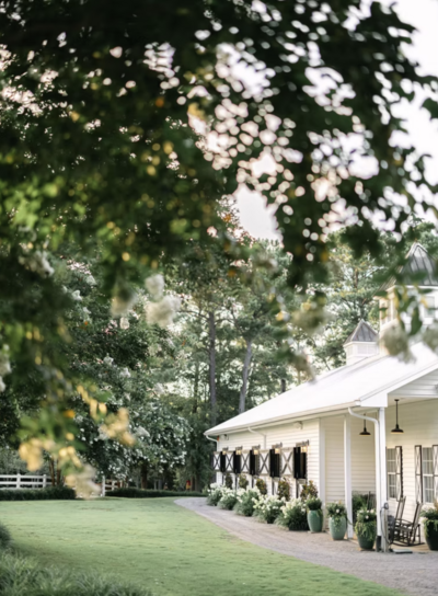 Sycamore Bend Estate wedding venue in Wilmington NC with white barn exterior and lush garden surroundings