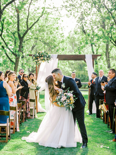 Celeste and Trent Kissing as They Walk Down the Aisle - Sara Bishop Photography