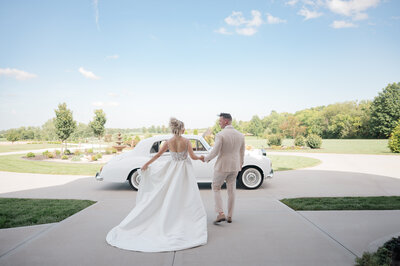 Bride and Groom share a kiss surrounded by sparklers in front of a vintage rolls Royce. Photo by Anna Brace, who specializes in Wedding Photography in Kansas City.