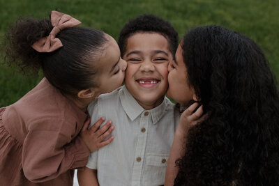 siblings kissing each other's cheeks