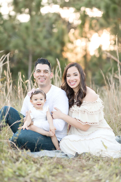 Family of 3 looking at the camera and smiling during their Miami photoshoot with Ivanna Vidal Photography