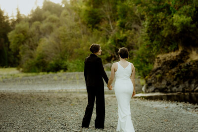 Two brides walk along the Eel river near the Benbow Inn in Garberville, California