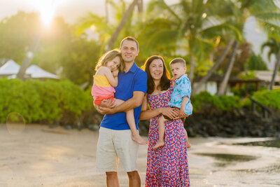 Family with their two young children smiles during their sunrise mini photo session