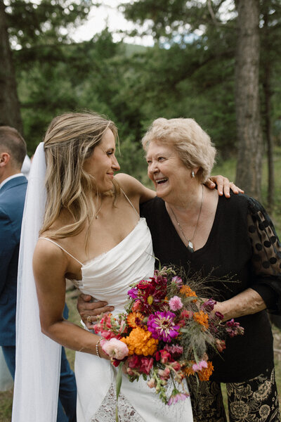 real wedding in alberta showing bride holding bouquet of flowers while looking at her grandma