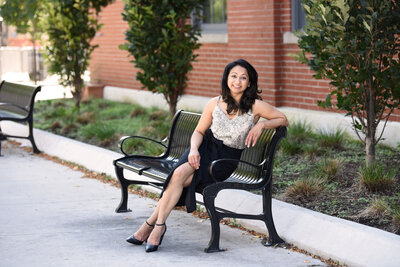 woman sitting on black bench in black skirt