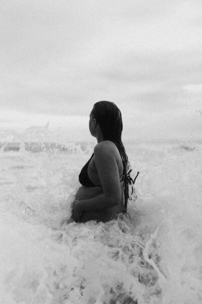 A pregnant woman captured in the Ohope beach sea. Maternity portrait captured by Eilish Burt Photography