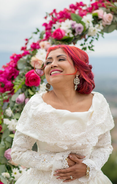 mixed race bride with colorful hair and makeup in a white dress for her wedding day in  San Jose, CA