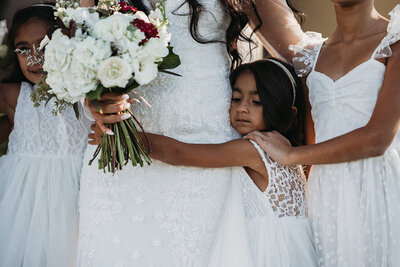 Child of the bride hugs her mother before the wedding ceremony