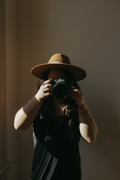 Woman standing with camera pointed at viewer
