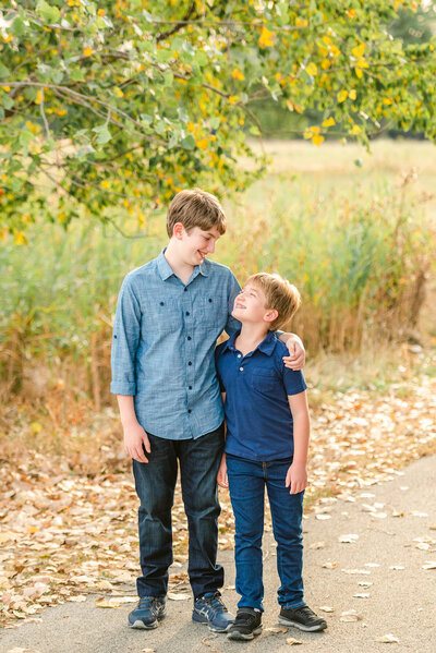 Big and little brother grinning at each other by Chicago family photographer Kristen Hazelton