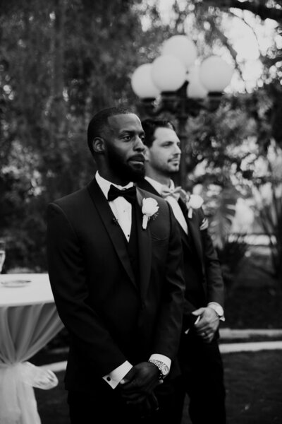Emotional groom and best man seeing  bride walking down the aisle