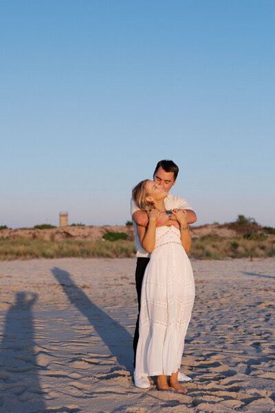Couple hugging in the golden light at Sunset beach in Cape May