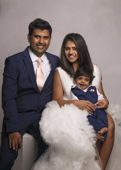 family of 3 posed in photo studio near seattle wearing suit and tie in blue and white
