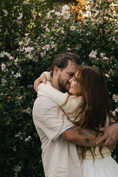 couple embracing and giggling in Tasmania estate garden