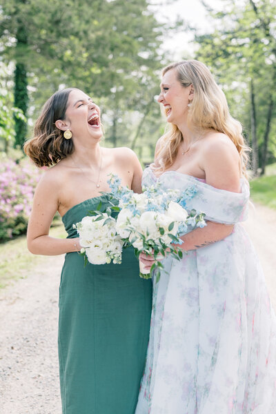 Atlanta Wedding Photographer | Bride And Bridesmaid Laughing While Holding White And Pale Blue Bouquets