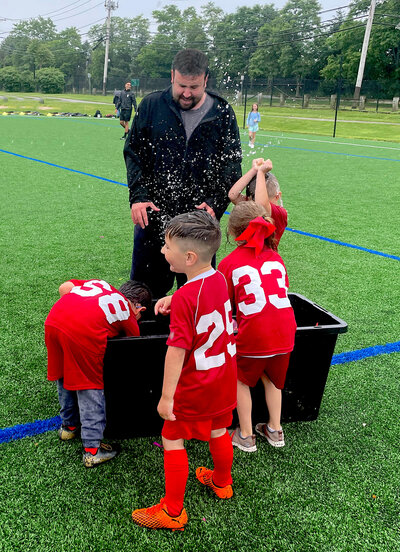 Man coaching soccer team sports coach water balloon fight fun kids soccer players, giving up my baby for adoption, unplanned pregnancy, long island, new york