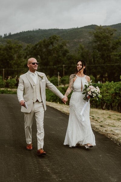 Couple walking hand-in-hand in a vineyard at B.R. Cohn during their all-day wine country elopement 