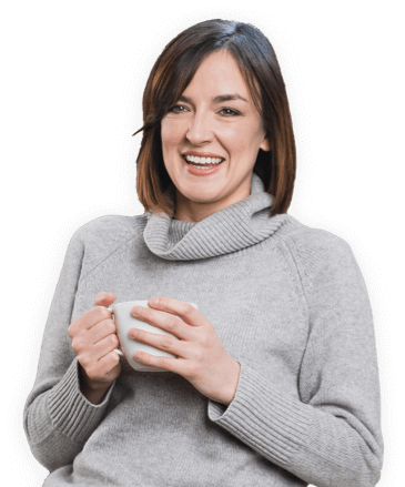Woman smiling and holding a mug, wearing a gray turtleneck sweater.