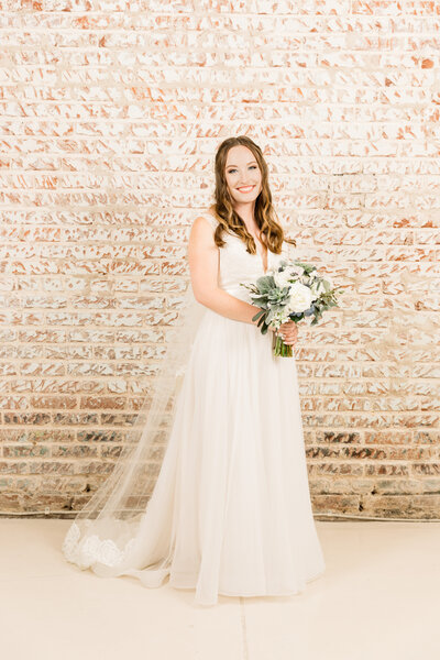 Bride smiles with bouquet on her wedding day