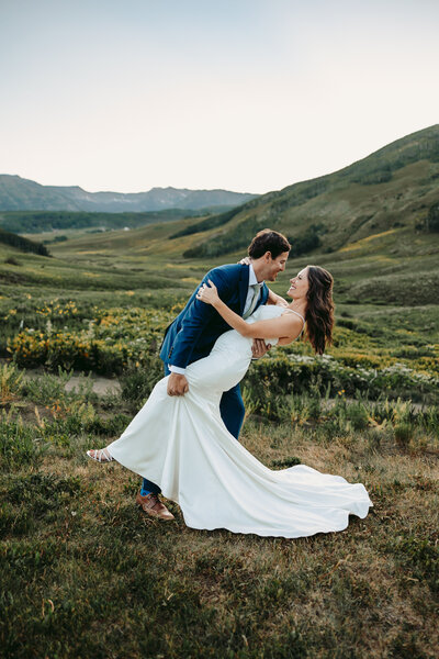 Groom dips bride for a kiss at Snodgrass Trail in Crested Butte.
