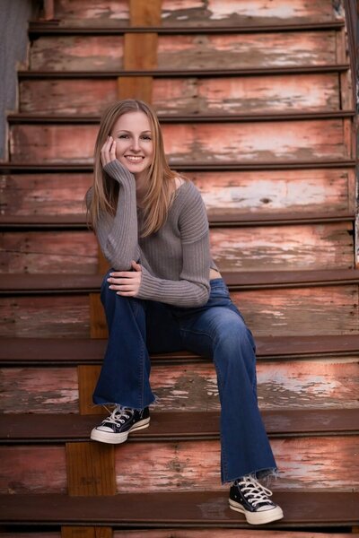 high school senior blond girl sitting in a grassy field