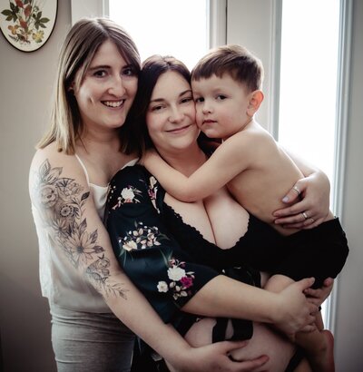 Edmonton moms hug each other and hold their son