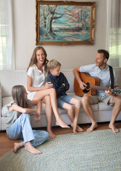A family playing guitar and listening to music together in their home